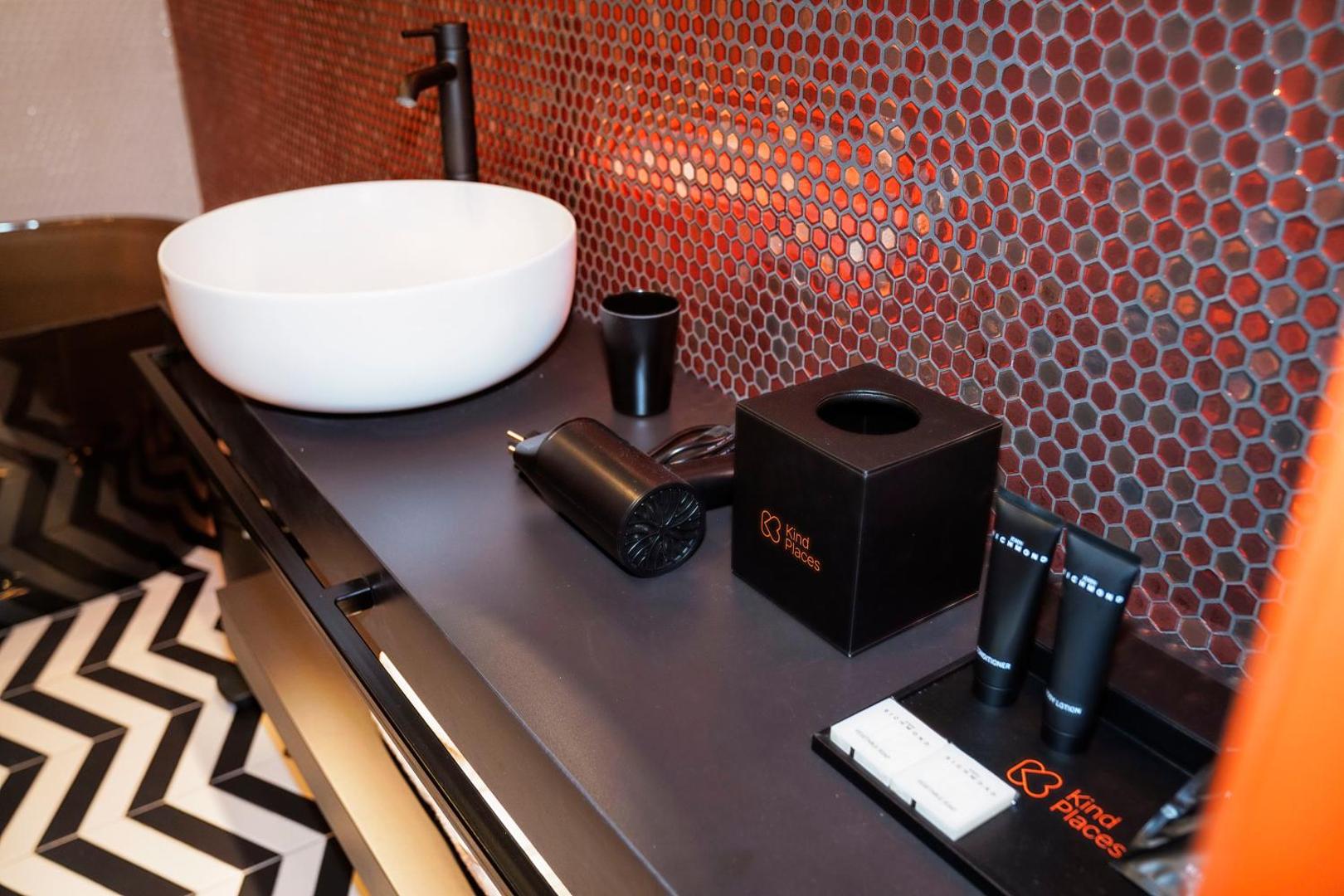 Mobile bagno nero con cortesie Kind Places e asciugacapelli