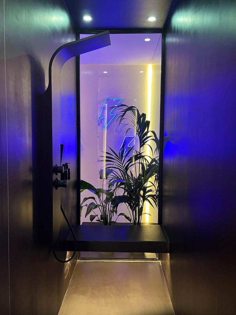 Doccia Hammam con cromoterapia, insegna al neon a fulmine e piante