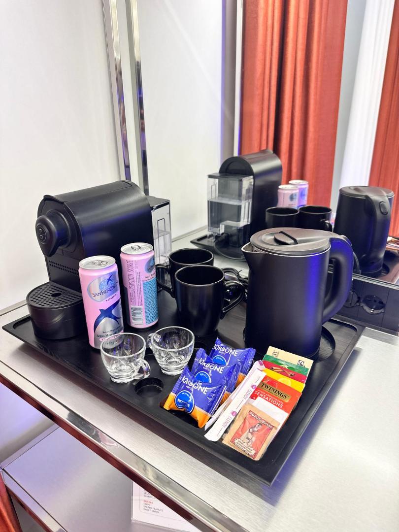 Angolo caffè e tè con macchina Nespresso, bollitore e bevande di benvenuto