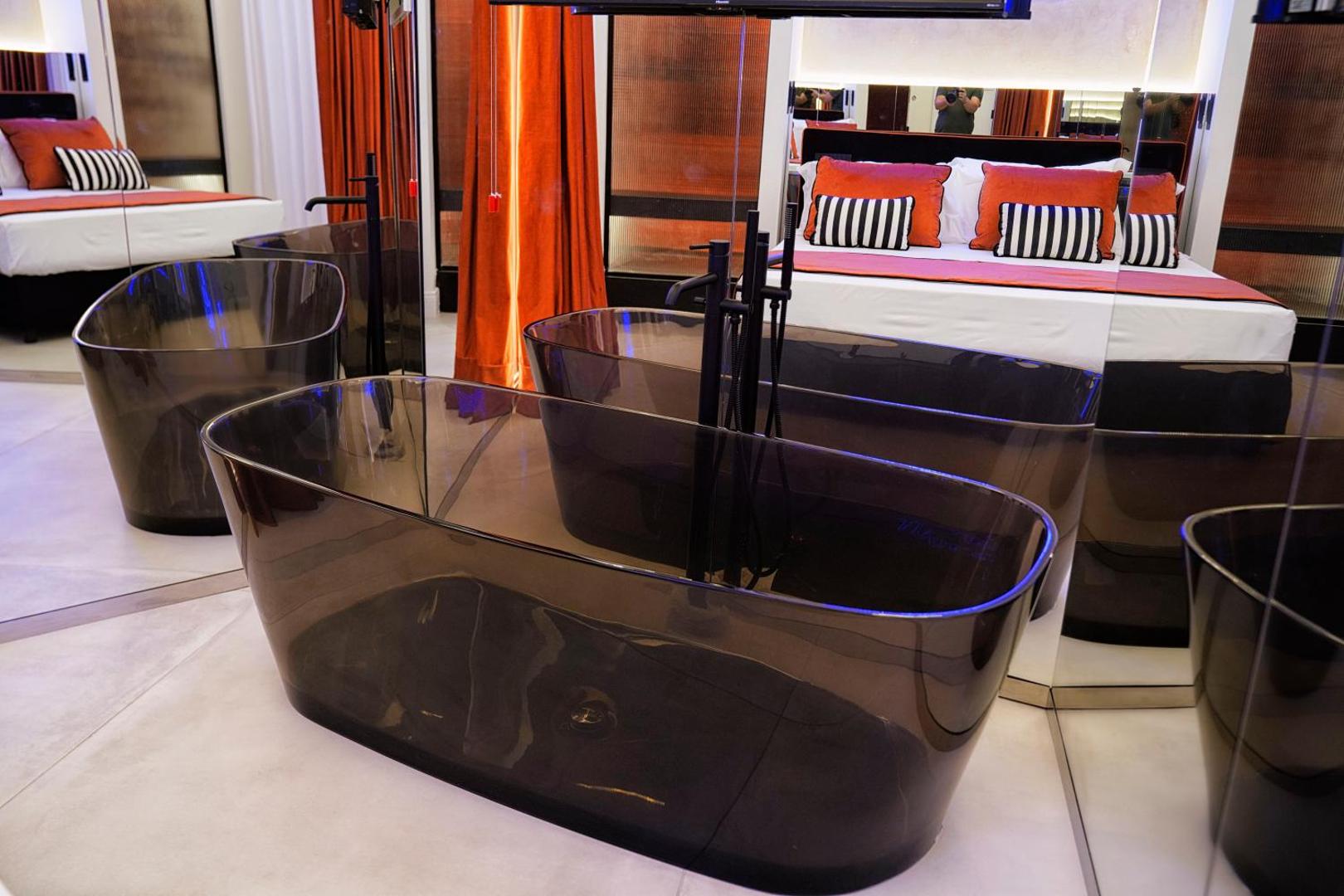Vasca freestanding trasparente fumé con il letto riflesso negli specchi